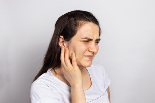 woman with jaw pain hand on face