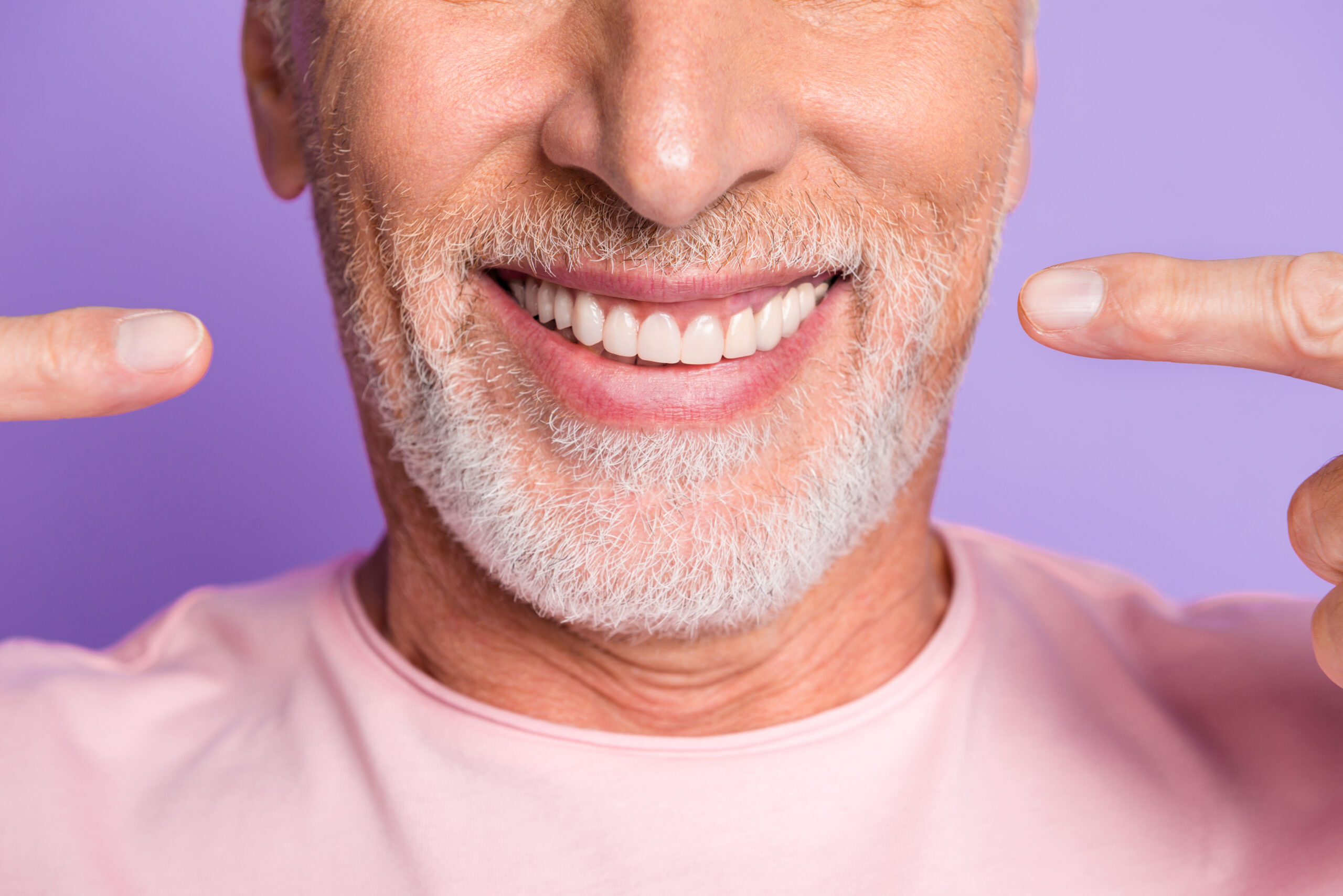 Cropped photo of retired old man face mouth direct fingers white shiny teeth wear pink t-shirt isolated violet color background