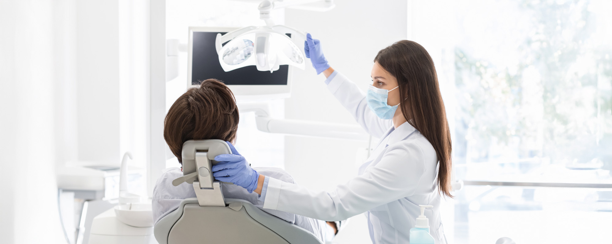 Female dentist greeting her patient sitting in chair