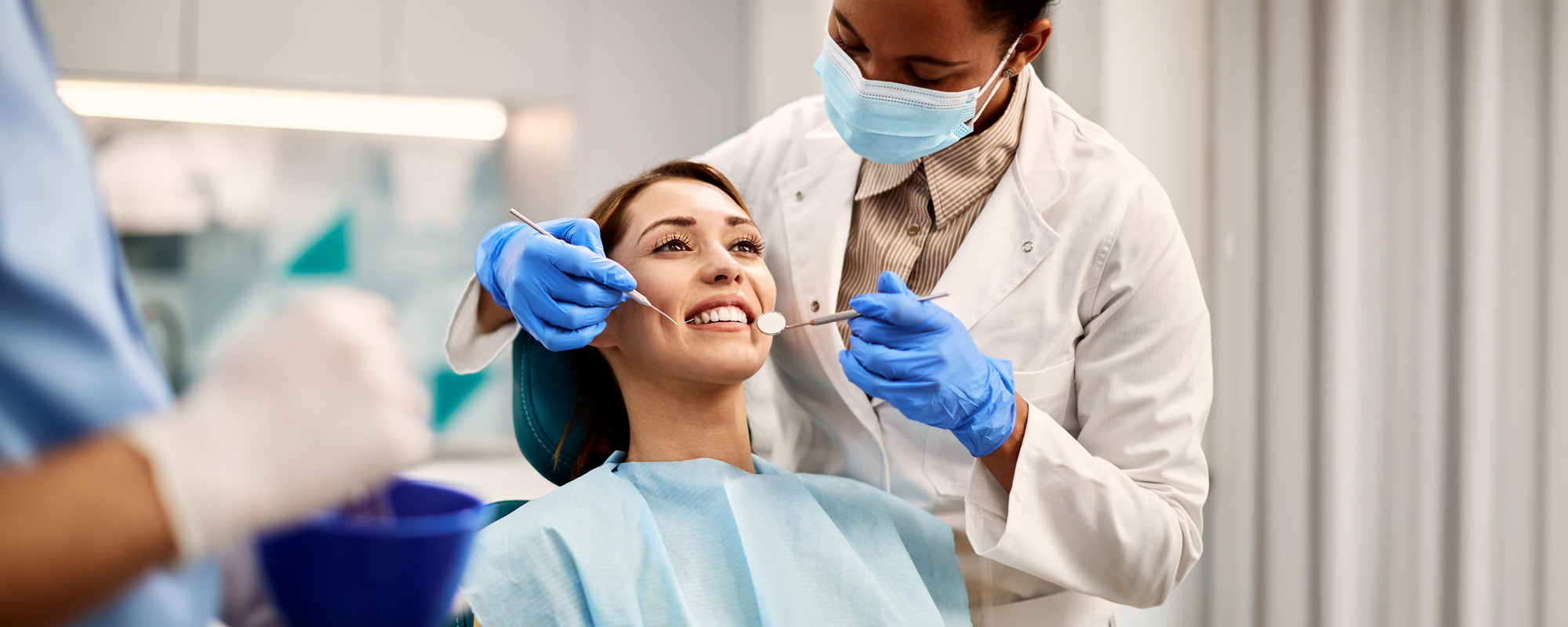 Young smiling woman having dental exam at dentists office