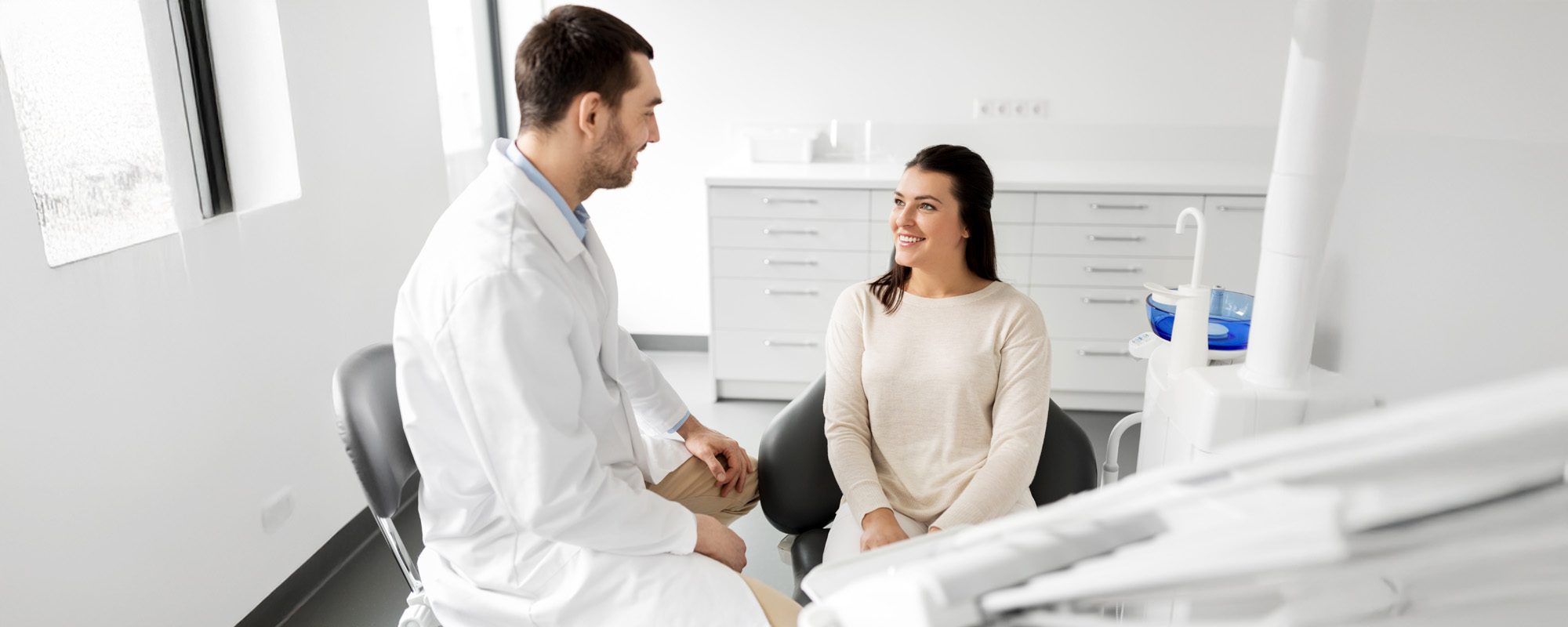 dentist talking to female patient at dental clinic