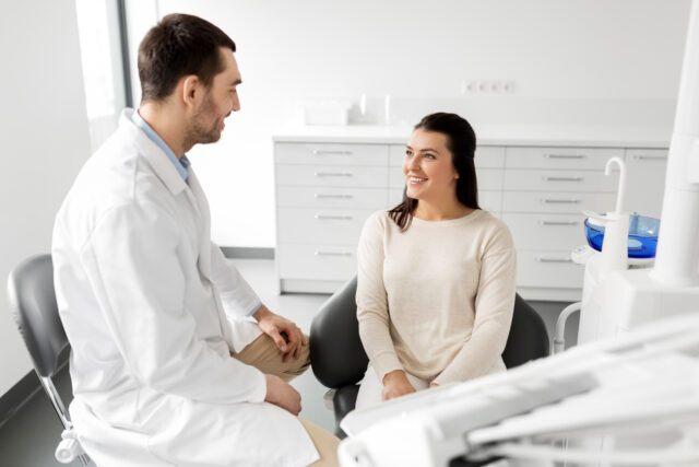 dentist talking to female patient at dental clinic